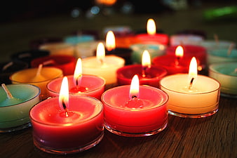 Colorful Tealight Candles Burning on Wooden Table