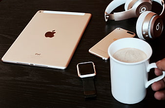 Gold Apple Devices, Smartwatch, and Coffee Mug on Dark Wooden Table