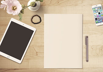 Flat lay workspace with tablet, notebook, and smartphone on wooden table