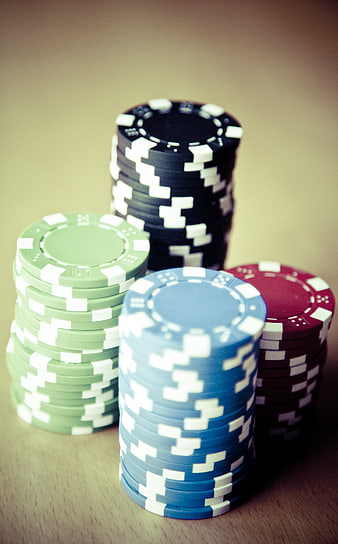 Stacks of colorful poker chips on wooden table