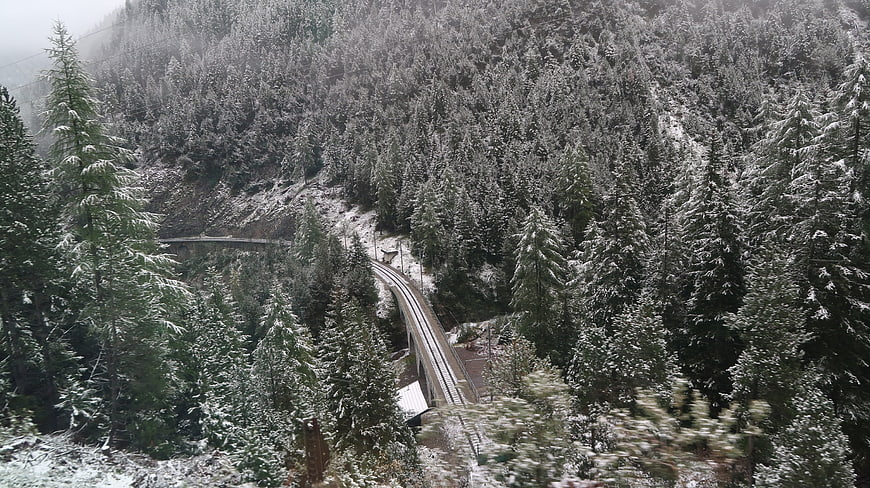 Snowy Mountain Railway Winding Through Alpine Forest