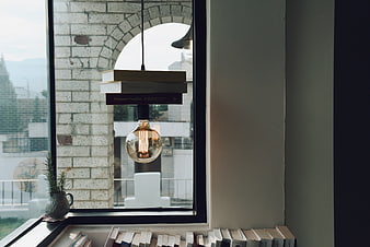 Vintage Edison Bulb Lamp Hanging by Window with Books