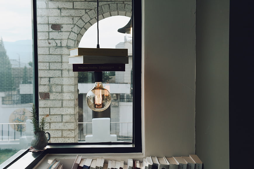 Vintage Edison Bulb Lamp Hanging by Window with Books