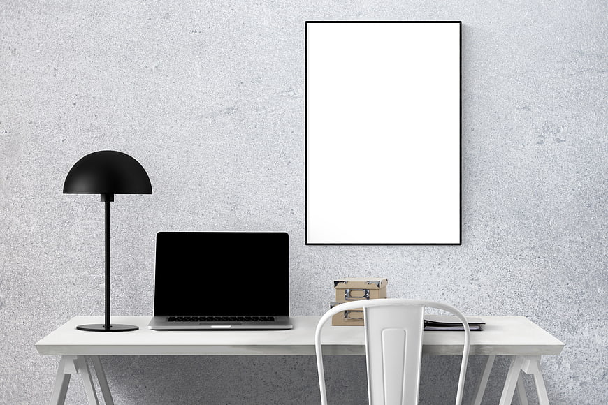 Minimalist White Office Desk with Laptop and Blank Poster Frame