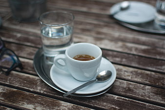 Espresso cup and water glass on rustic wooden table