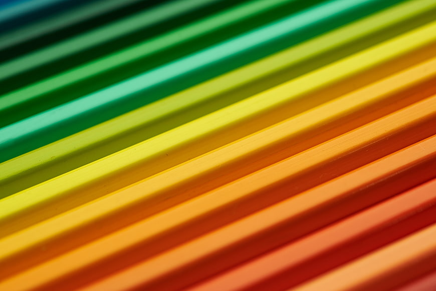 Close-up of colorful pencils arranged in a rainbow gradient pattern