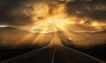 Sunlit Highway Stretching to Horizon with Dramatic Clouds