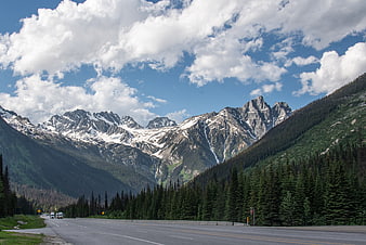 Scenic highway winding through snow-capped Rocky Mountains