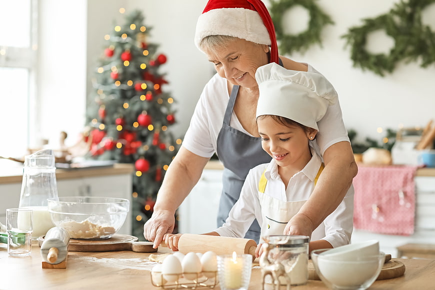 Grandmother and granddaughter baking Christmas cookies together in kitchen