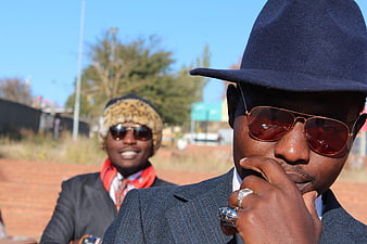 Two stylish men in suits and sunglasses outdoors