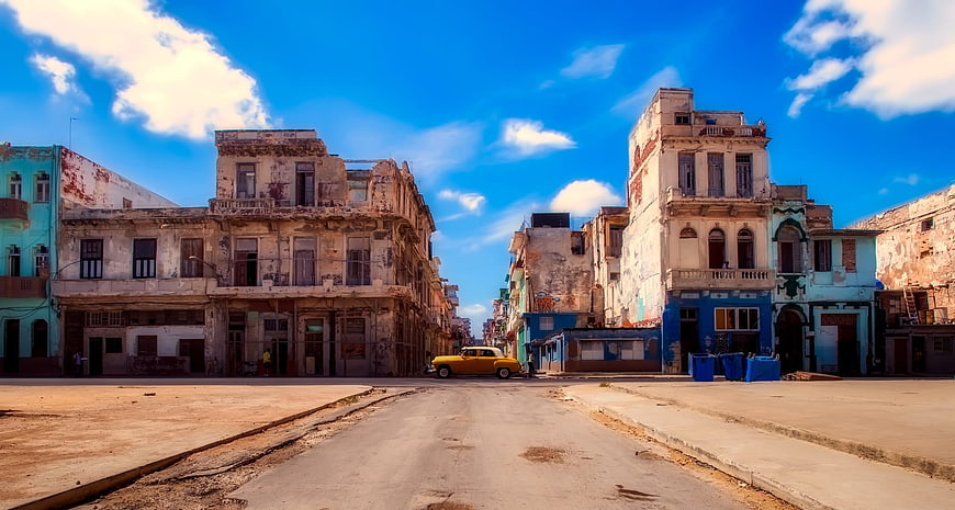 Vintage yellow car on Havana street with old buildings