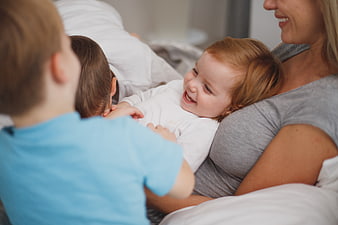 Happy family cuddling and laughing together in bed
