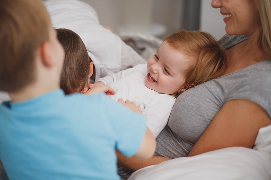 Happy family cuddling and laughing together in bed