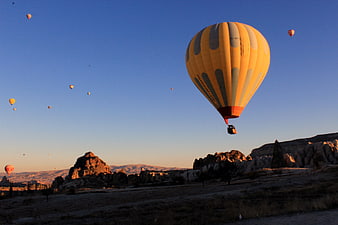 Hot Air Balloons Flying Over Cappadocia Landscape at Sunrise