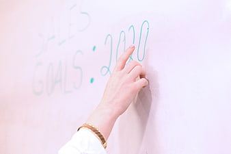 Hand writing 2020 goals on whiteboard