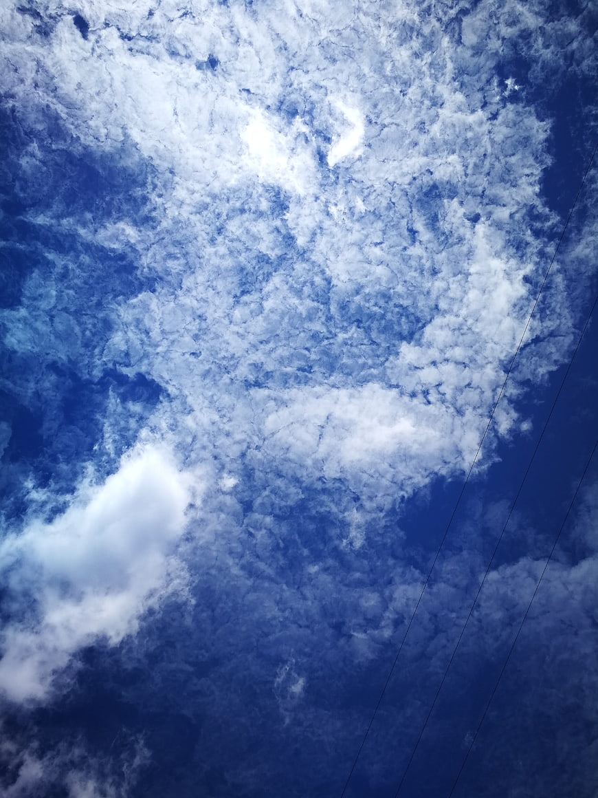 Blue sky with textured clouds and power lines