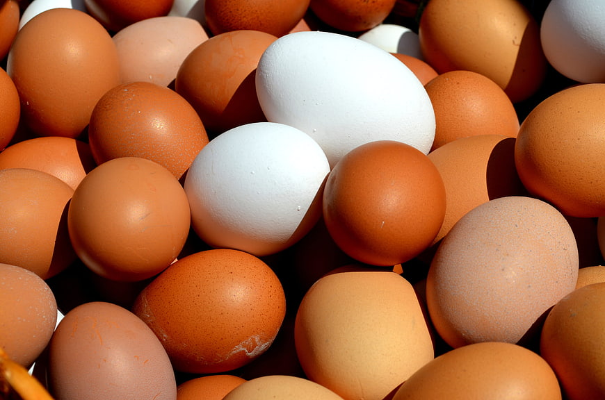 Close-up of assorted brown and white chicken eggs in a pile