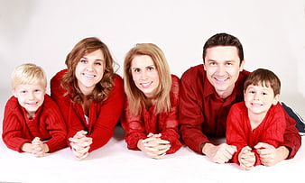 Happy family in red clothes lying on white background