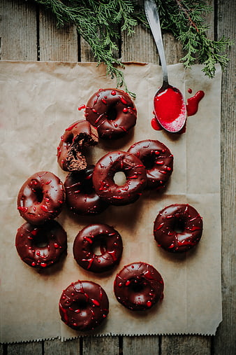 Chocolate donuts with red glaze on parchment paper