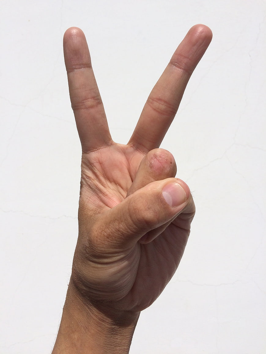 Hand making peace sign gesture against white background