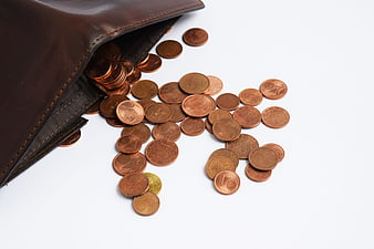 Euro coins spilling from brown leather wallet on white background