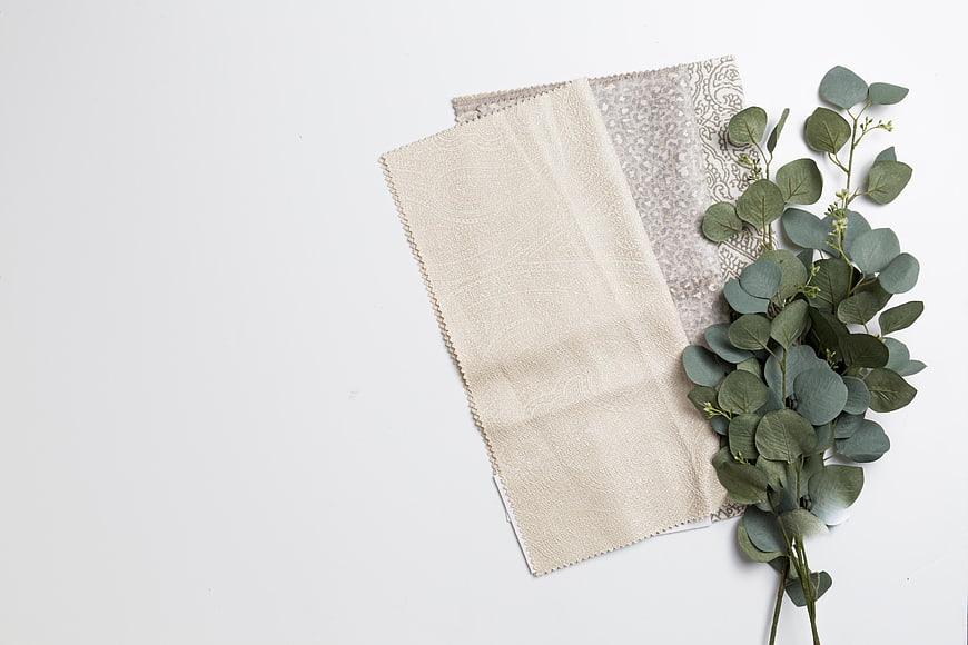 Minimalist fabric swatches and eucalyptus on white background