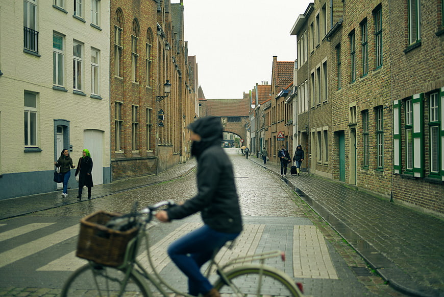 Cyclist on Cobblestone Street in European City
