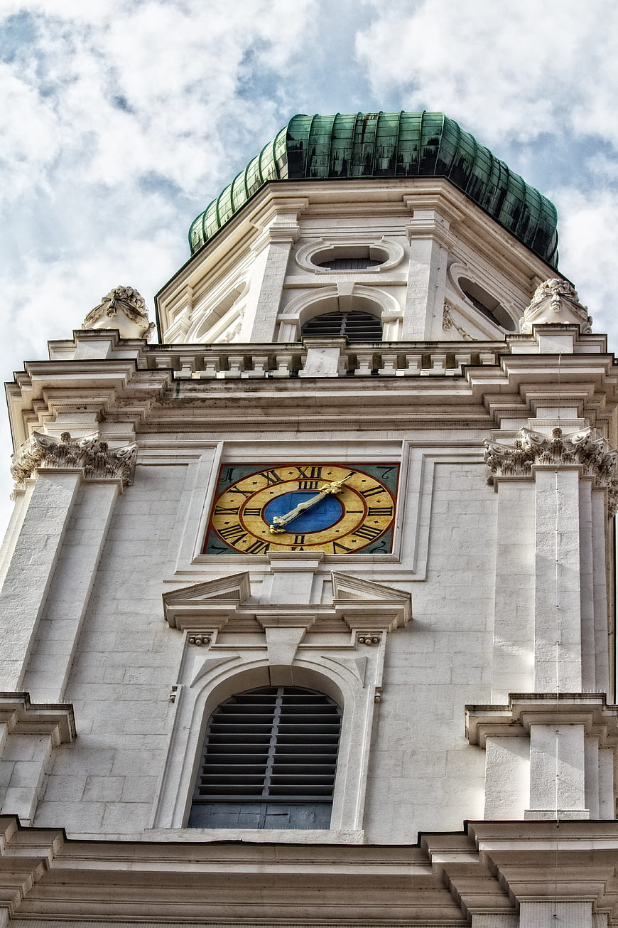 Low angle view of baroque church tower with green dome and clock