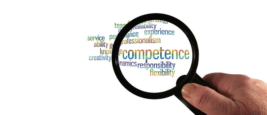 Magnifying glass focusing on competence word cloud