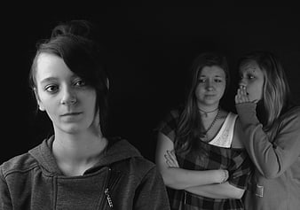Black and white portrait of three teenage girls gossiping