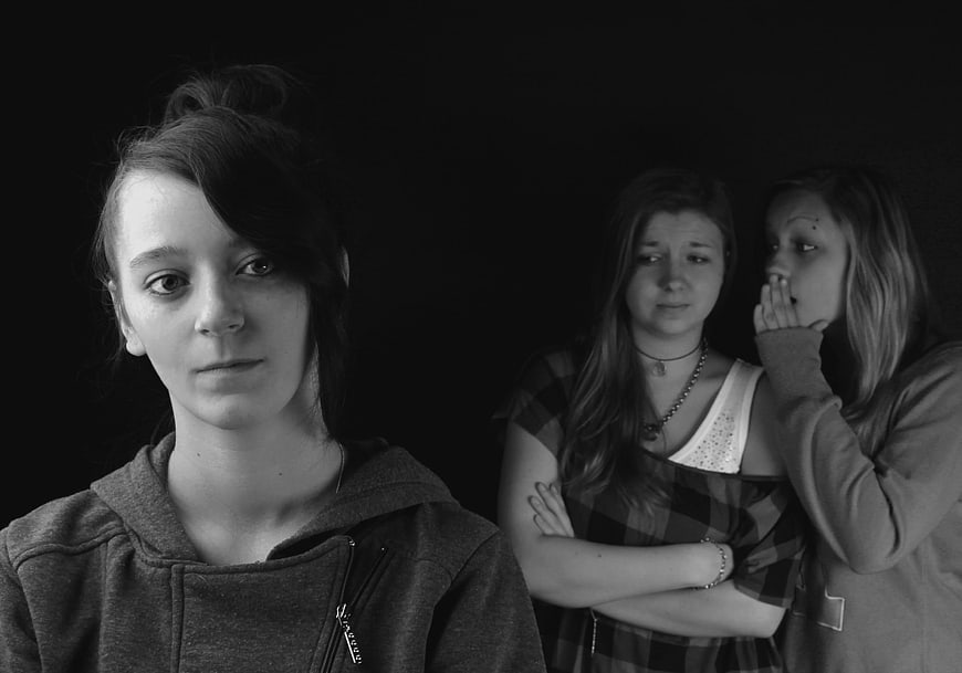 Black and white portrait of three teenage girls gossiping