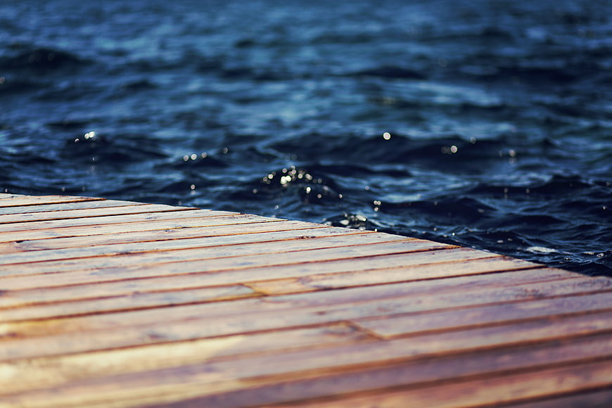 Wooden Dock Planks Meeting Blue Water Edge