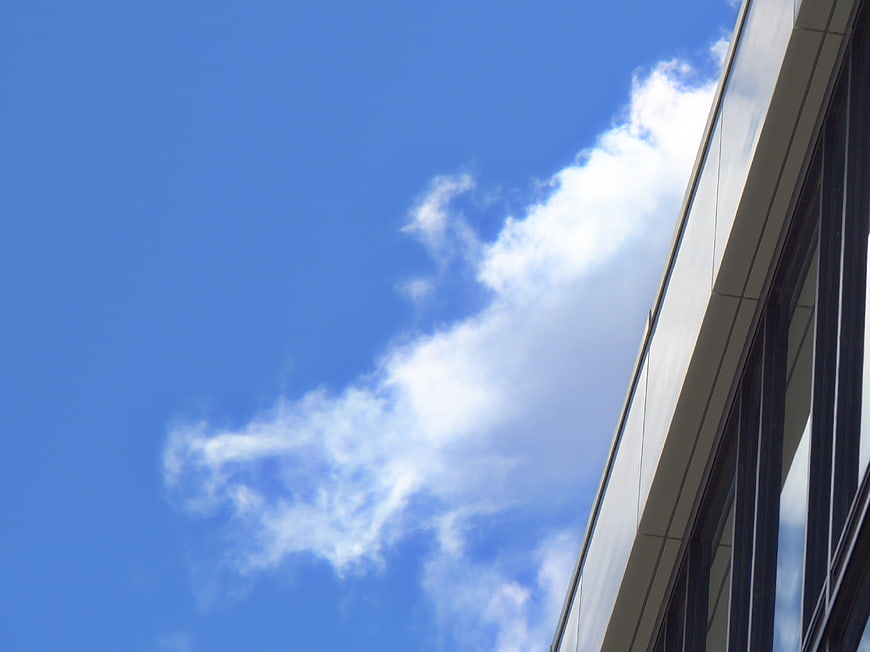 Modern building facade against blue sky with clouds