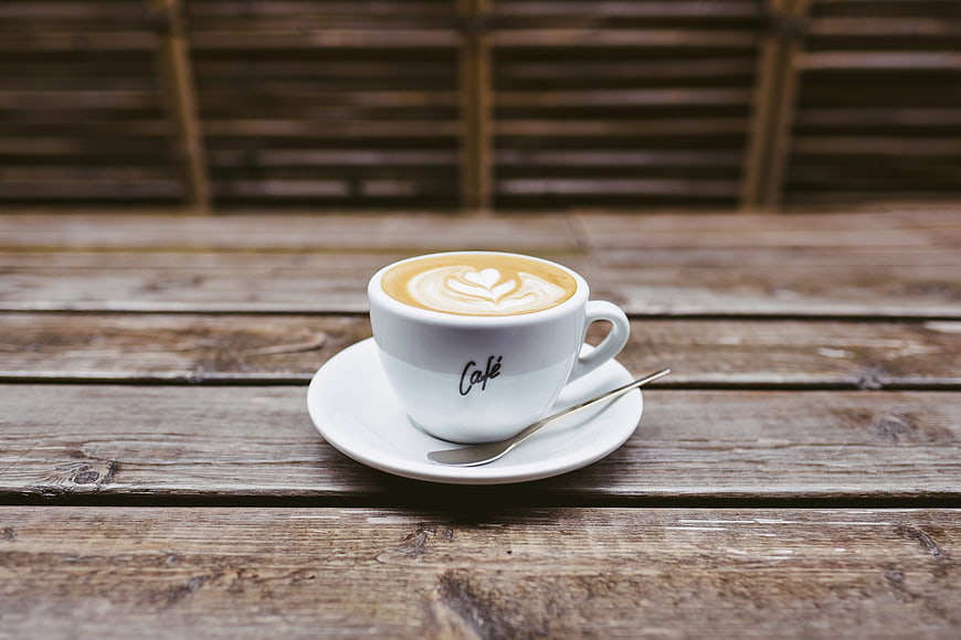White Latte Cup With Heart Art On Rustic Wooden Table