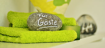 Inscribed Stone on Green Towels in Hotel Bathroom