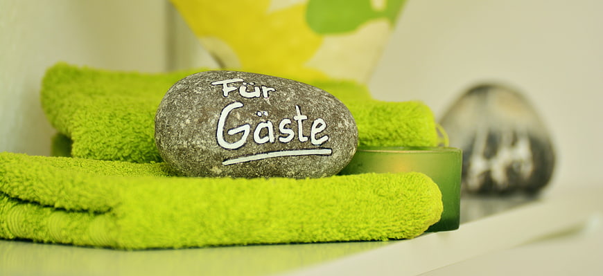 Inscribed Stone on Green Towels in Hotel Bathroom