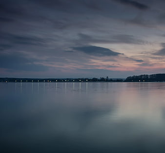 Serene Lake at Dusk with City Lights Reflection