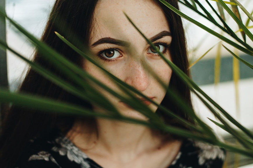 Mysterious Woman Portrait Through Green Palm Leaves