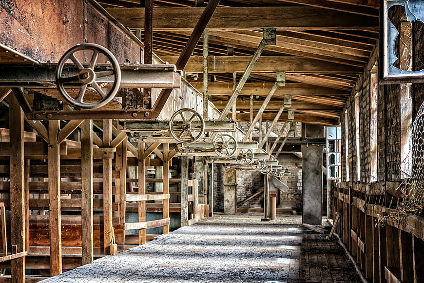 Abandoned Industrial Factory Interior With Rusty Machinery And Wooden Beams