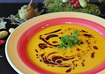 Creamy Pumpkin Soup with Balsamic Drizzle and Parsley Garnish