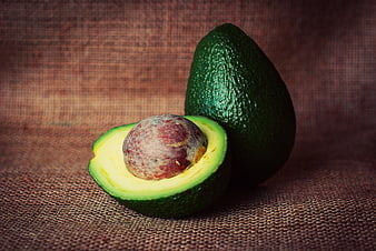 Fresh Avocado Half with Pit on Rustic Burlap Background