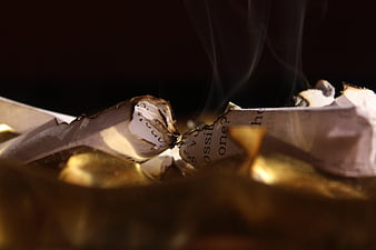 Burning paper with smoke rising in dark moody setting