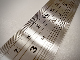 Close-up of metal ruler on white textured surface