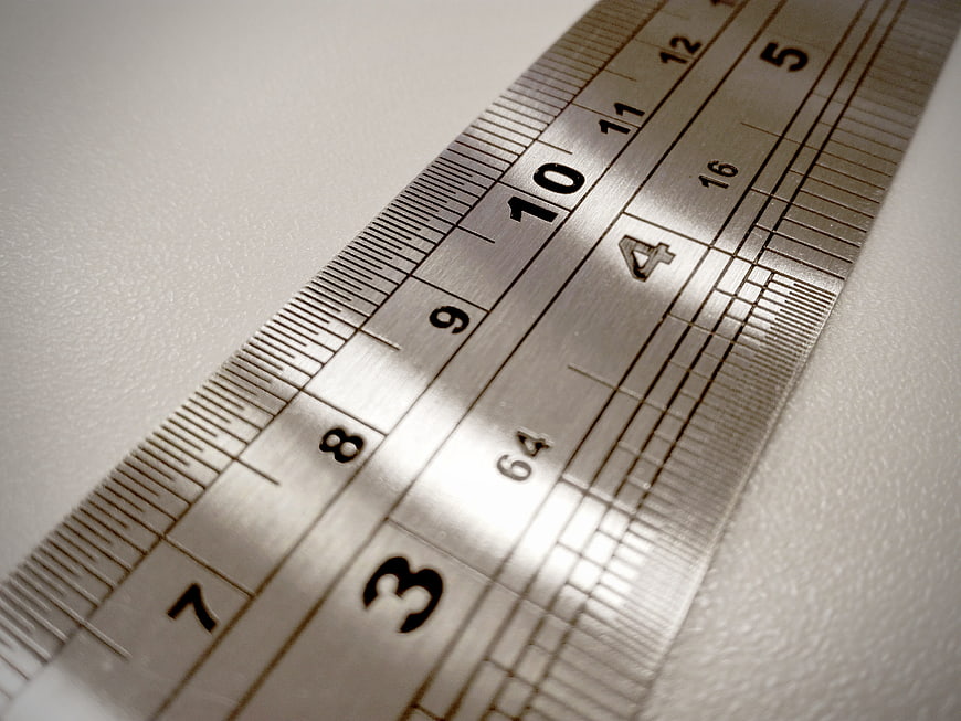 Close-up of metal ruler on white textured surface