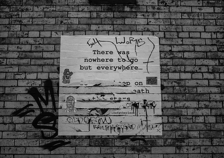 Black and white street art poster on brick wall