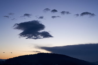 Dramatic sunset clouds over silhouetted mountain ridge