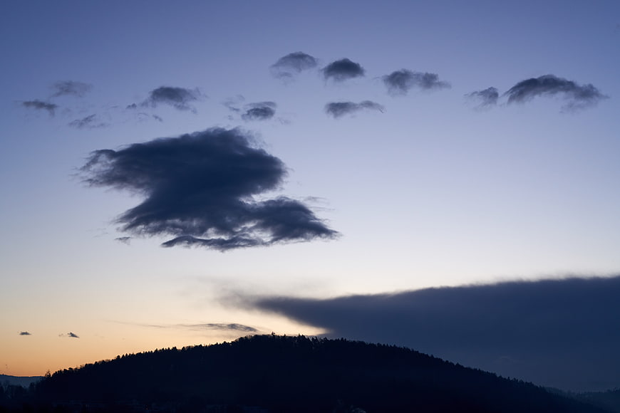 Dramatic sunset clouds over silhouetted mountain ridge