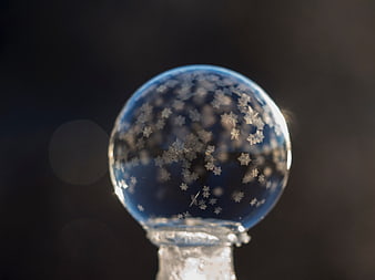 Close-up of a blue glass ornament with star-shaped snowflakes