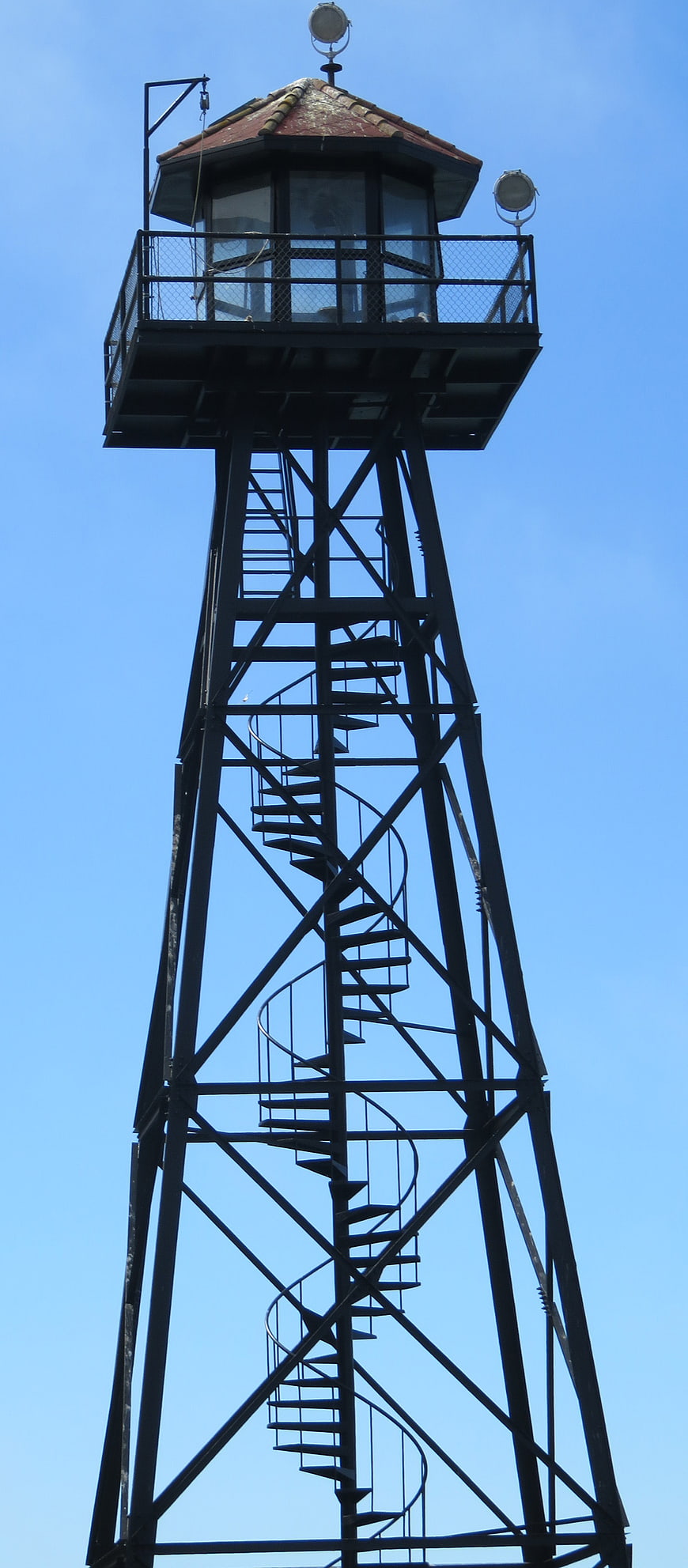 Metal Guard Tower with Spiral Staircase Against Blue Sky