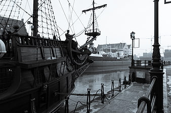Historic wooden sailing ship docked in harbor
